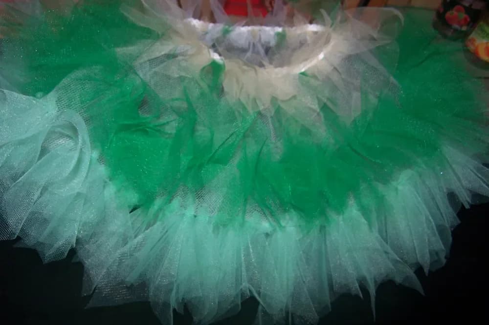 Gros plan sur une jupe tutu en tulle vert émeraude, vert d'eau et blanc