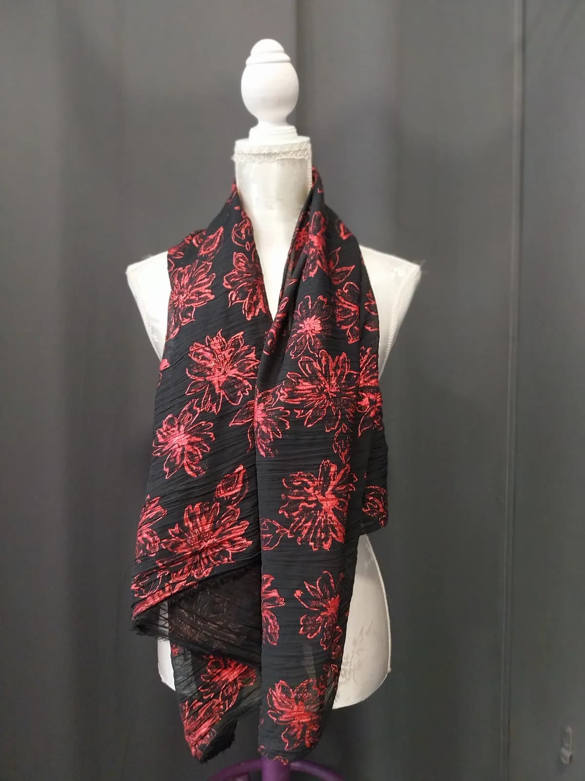Foulard noir à motifs floraux rouges, présenté sur un buste de couturière