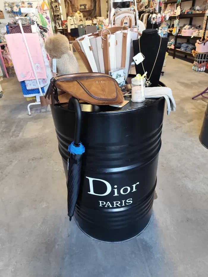 Tonneau « Dior Paris » présentant sacs, pochette en cuir marron, bonnet, collier doré et parapluie