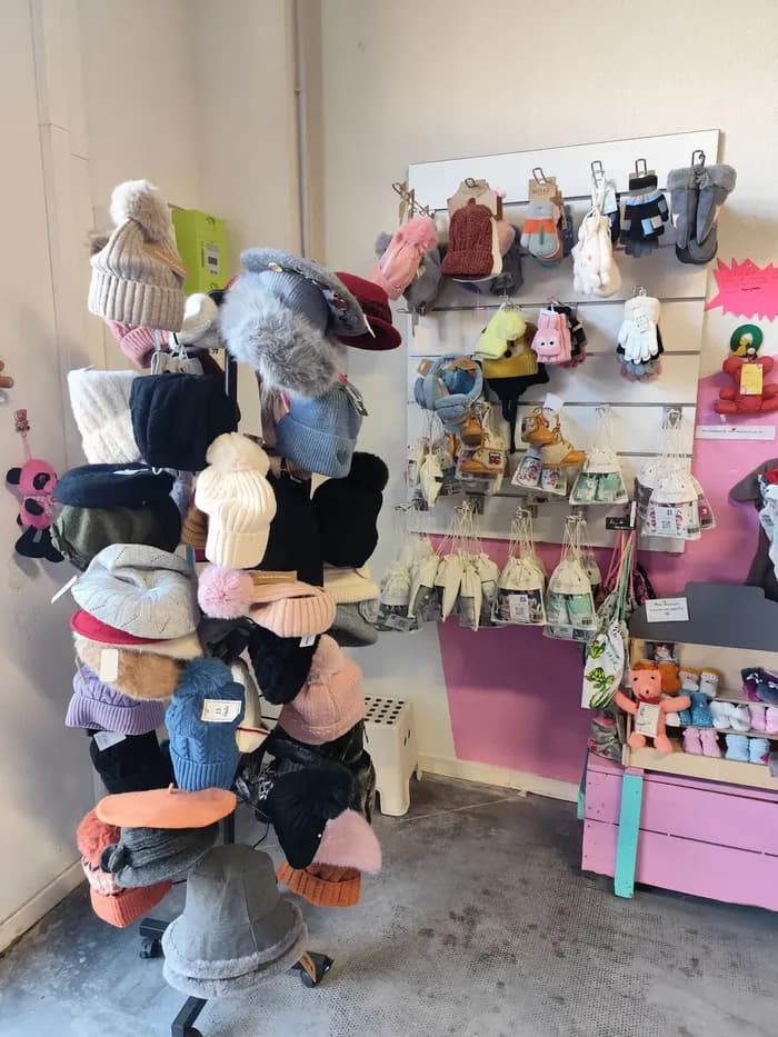 Présentoir de bonnets et gants d'hiver colorés, avec chaussons pour bébé accrochés au mur