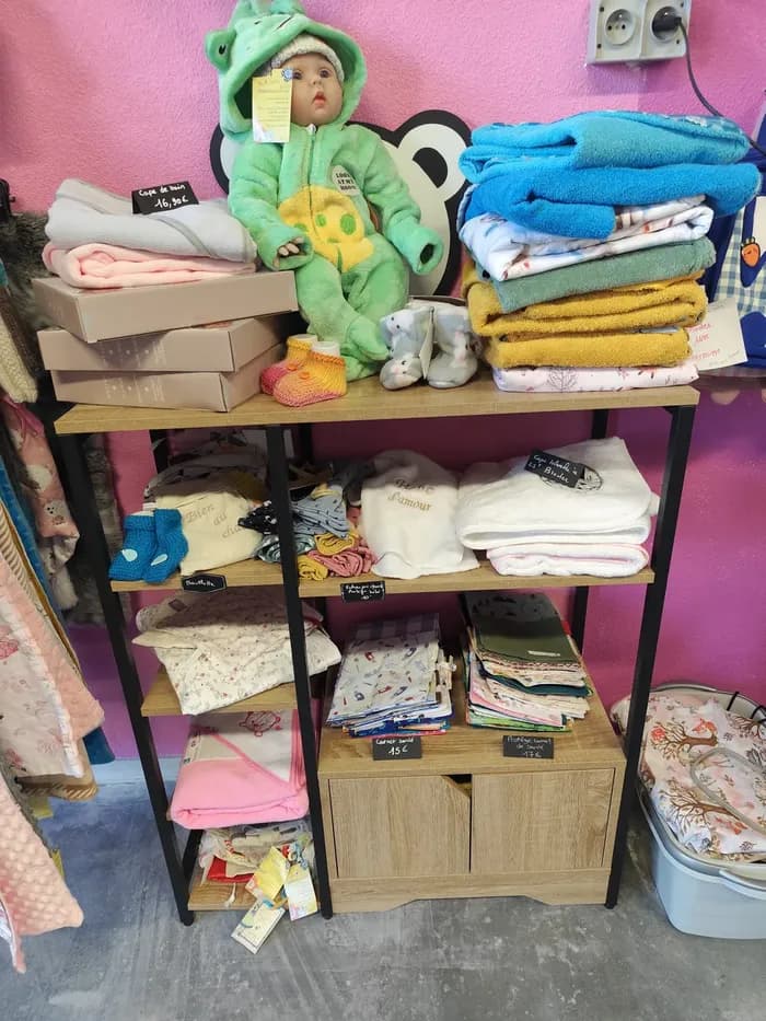 Étagère de linges de bain et capes de bain pour bébé, avec un doudou grenouille et des carnets de santé