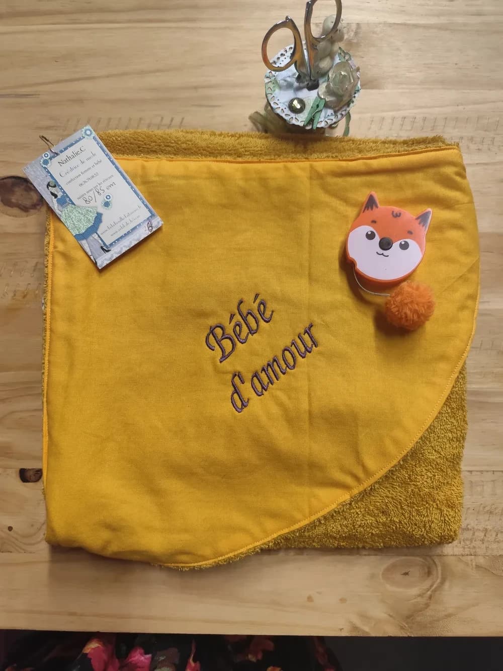 Cape de bain pour bébé en éponge couleur ocre, avec une capuche jaune brodée des mots « bébé d'amour »