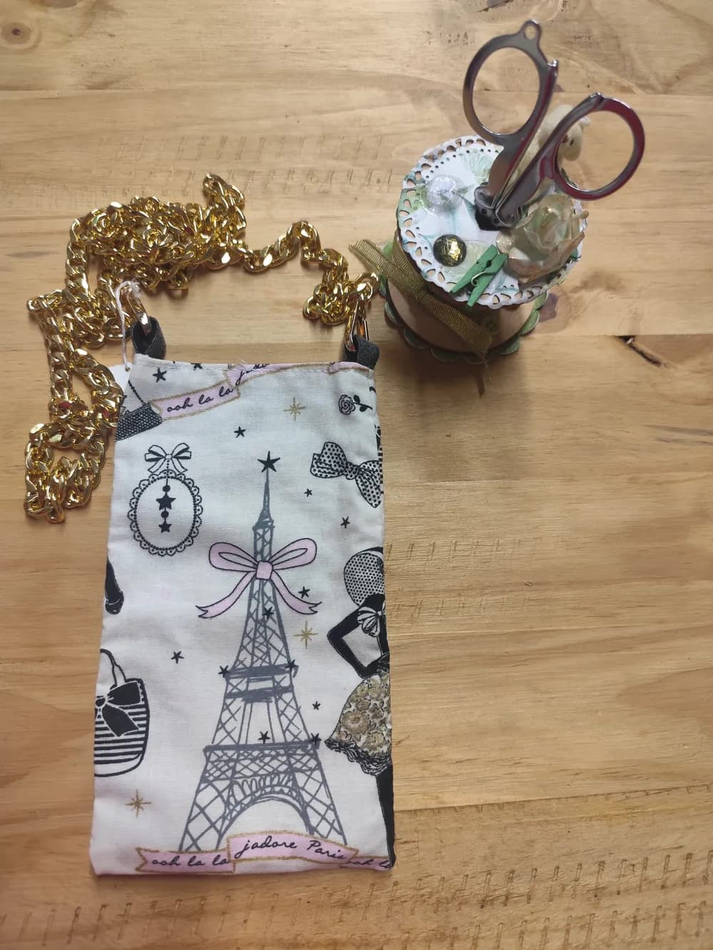 Sac pochette téléphone en tissu coton blanc illustré de la Tour Eiffel grise, nœuds roses et étoiles dorées, chaîne dorée épaisse en bandoulière